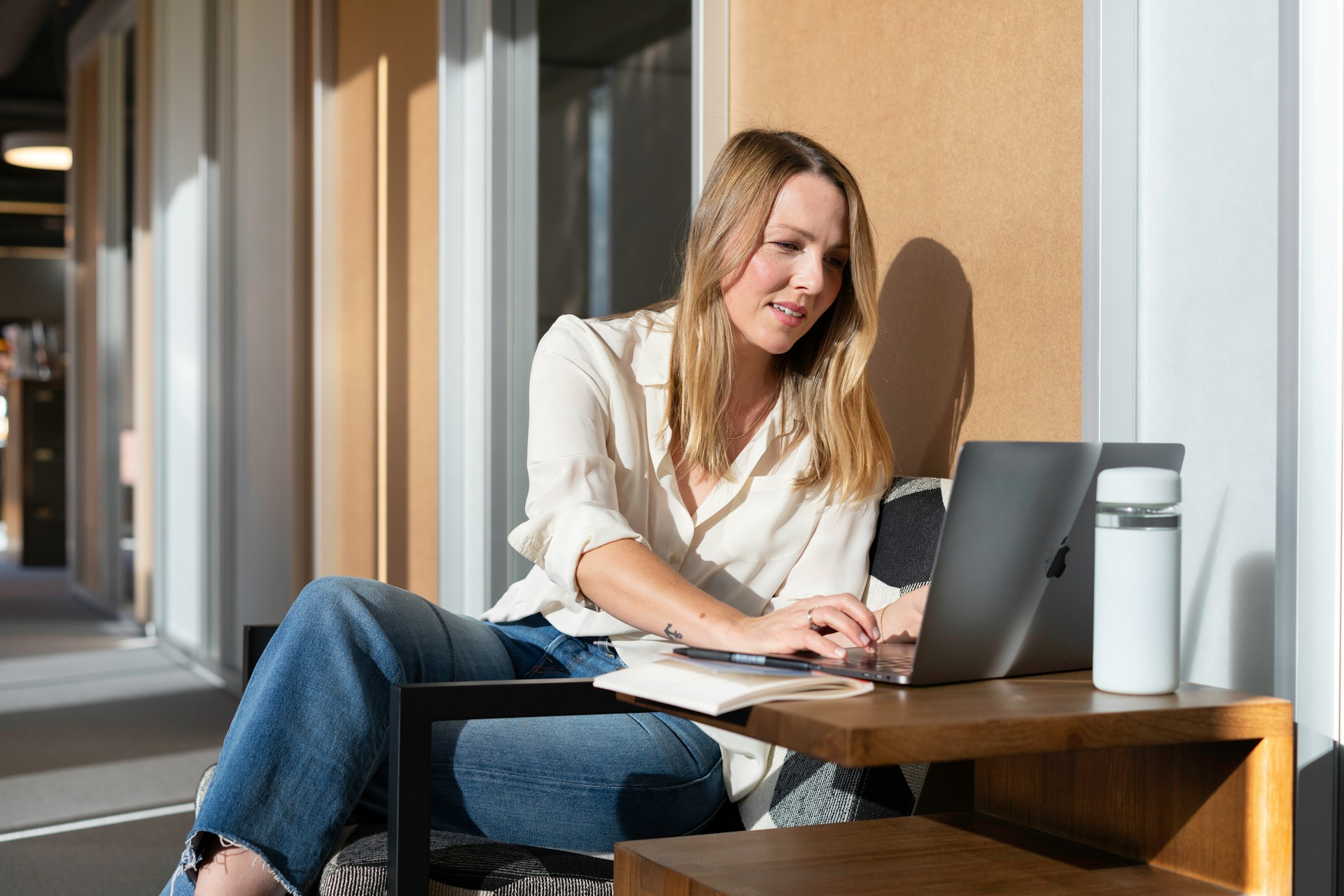 A salesperson working in an office at a laptop in the sun